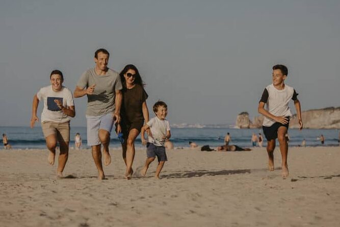 Famille qui court sur le sable fin de la Grande Plage, à Hendaye